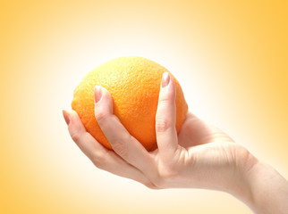 A fresh and healthy orange is held in a young female hand