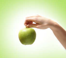 A fresh and healthy apple is held in a young female hand