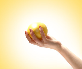 A fresh and healthy grapefruit is held in a young female hand