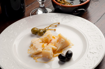 snack of pieces of grana with honey - grana miele olive