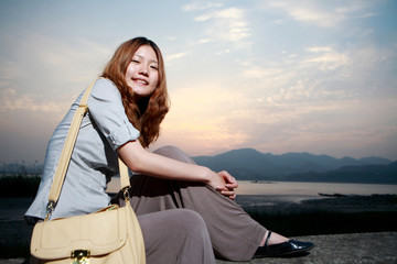 Fototapeta premium Beautiful young woman on the beach at sunset .