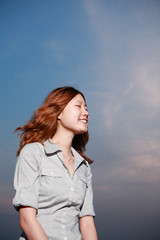 Beautiful young woman on the beach at sunset .