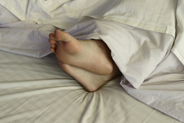 A woman's feet under a blanket
