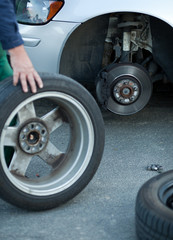 mechanic changing a wheel of a modern car (color toned image)