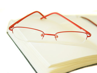 Notebook made of a red skin and glasses