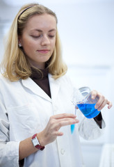 Portrait of a pretty female researcher carrying out experiments