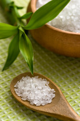 Sea salt bath in wooden bowl on bamboo mat
