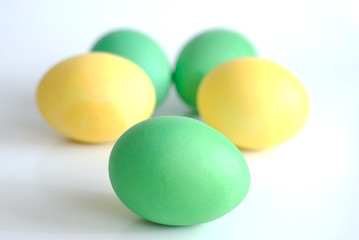 five yellow and green Easter eggs isolated on white