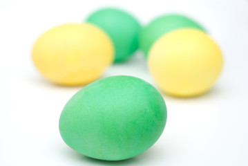five yellow and green Easter eggs isolated on white