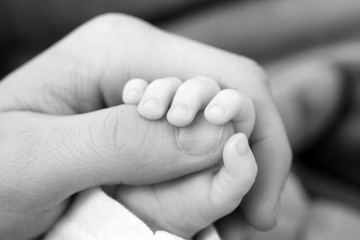 Baby hand holding on to father's finger