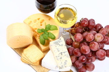 Various types of cheese, grapes, wine  and crackers