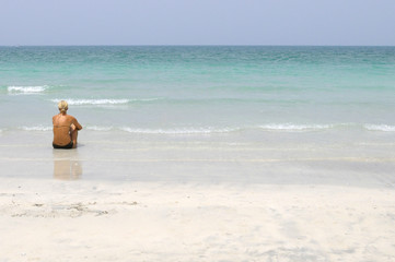 Fototapeta na wymiar donna bionda seduta in riva al mare