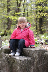 Happy Little Girl Sitting on Rock