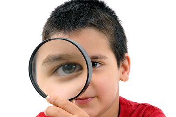 Little child looking through a magnifying glass isolated
