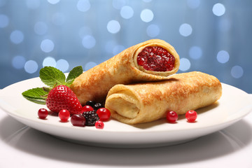 Вкусные блины с ягодами и клубникой на тарелке  на...