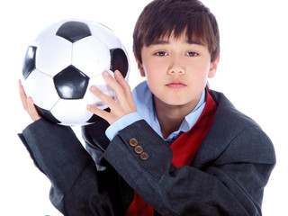 boy in business suit holding a soccer ball at shoulder level