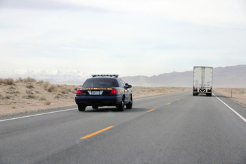 Police car patrol on high way cross desert.