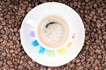 Multicolored slabs of shugar and cup of coffee