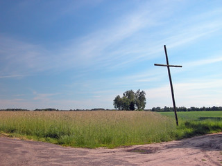 Wayside cross in rural landscape