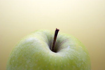 green apple against yellow background