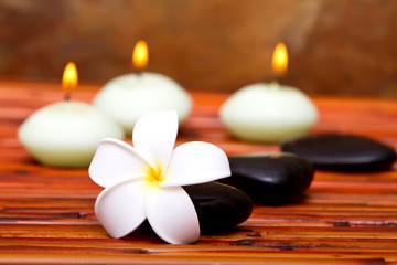 Obraz na płótnie Canvas Spa stones, candles and frangipani flower