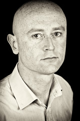 male in his 30's in shirt on black back drop