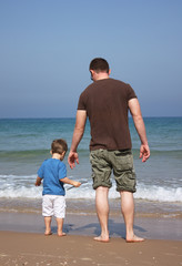 Father and son look at the sea