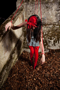 Beautiful girl posing as a marionette (puppet on a string)