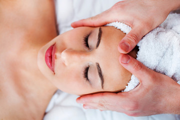 Obraz na płótnie Canvas Young pretty woman getting face massage in spa