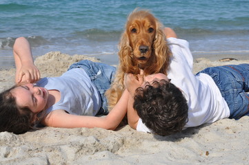 2 enfants et leur chien heureux sur la plage