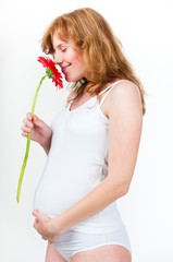 young pregnant sniffs flower