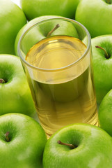 Glass with juice on a background of apples