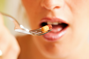 Woman eating nutritional supplements