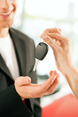 man buying car - key being given