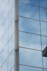 Fototapeta na wymiar Sky mirrored on the windows of a modern glass building.