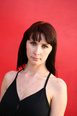 girl is posing against red wall