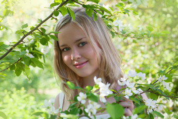 Young woman in spring blossom of apple trees