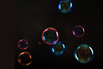 Soap bubbles on black background .