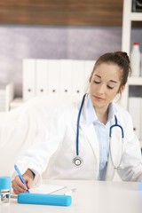 Young female doctor working at desk