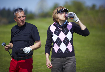 Golf couple sharing a drink on the golf course. - 22813980