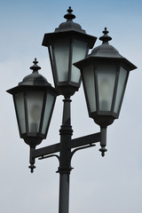 Fototapeta na wymiar three lanterns on a post on a background sky