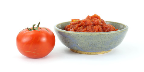 Red ripe tomato and a bowl of crushed tomatoes