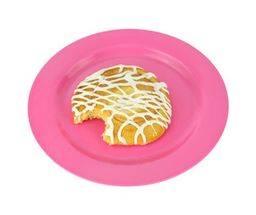 Freshly bitten cheese danish on a pink plate