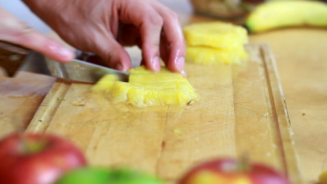 Slicing pineapple - Preparing fruit salad close-up