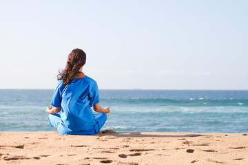 nurse meditating on beach - 22833995