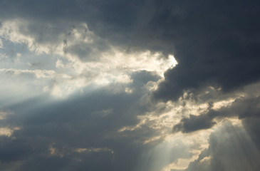 Obraz premium Big rays of light through grey clouds