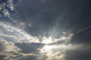 Obraz premium Powerful rays of sunlight through many clouds