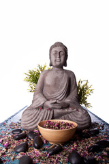 Buddha mit Massage Steinen und Schale voll Blüten