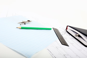 A compass on a graph paper with notepad