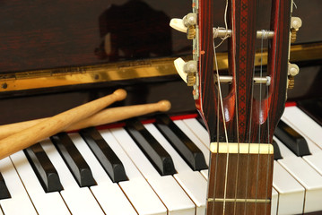 Drum sticks, guitar and piano keyboard